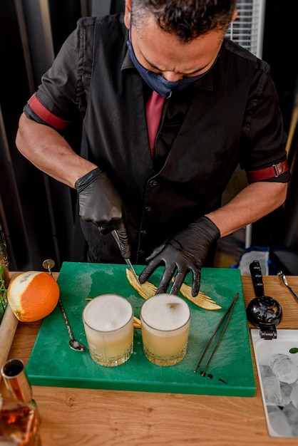 Camarero preparando y decorando cócteles en el concepto de profesión de bar