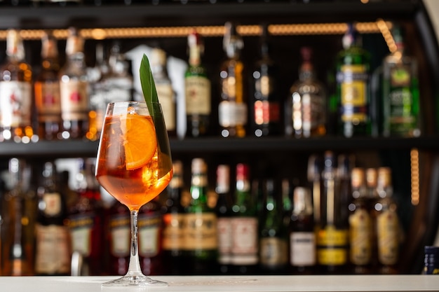 Camarero preparando en el mostrador Aperol Spritz un clásico aperitivo italiano refrescante hecho mezcla