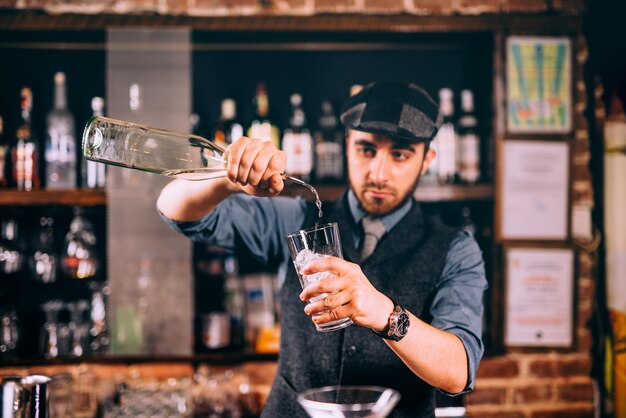 Camarero profesional vertiendo ron en cócteles en el bar pub o restaurante