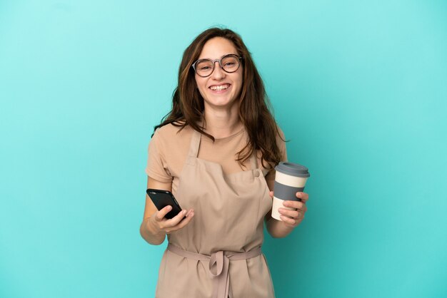 Camarero de restaurante con café para llevar y un móvil