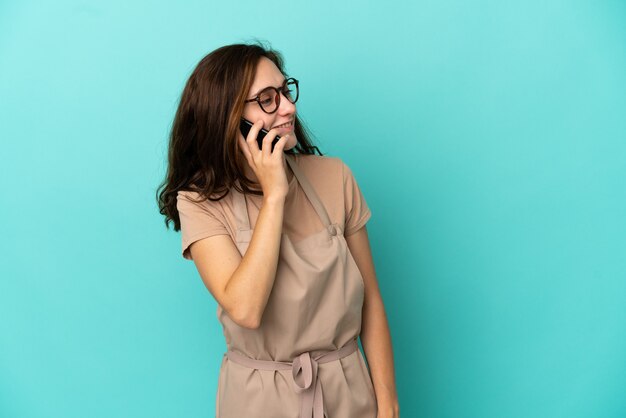 Camarero de restaurante manteniendo una conversación con el teléfono móvil con alguien