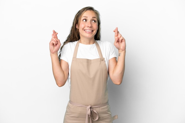 Foto camarero de restaurante mujer caucásica aislada sobre fondo blanco con los dedos cruzados