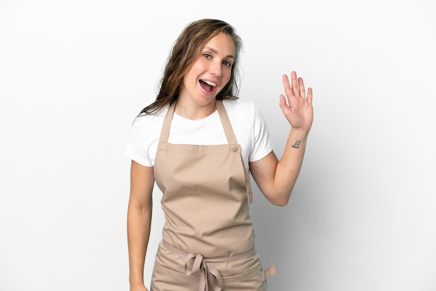 Camarero de restaurante mujer caucásica aislada sobre fondo blanco saludando con la mano con expresión feliz