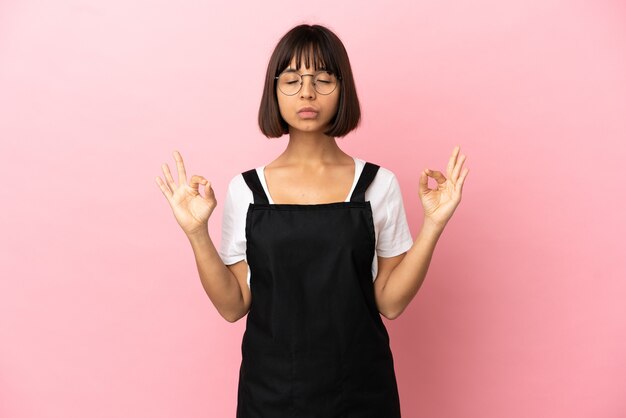 Camarero de restaurante sobre fondo rosa aislado en pose zen