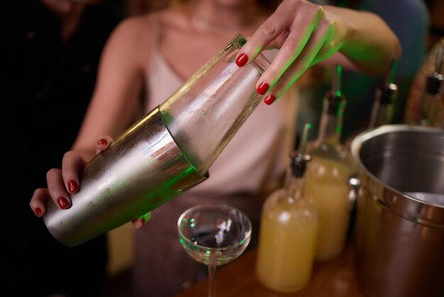 Camarero sirviendo bebidas alcohólicas fuertes en vasos pequeños en chupitos de barra