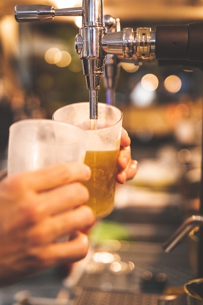 Camarero sirviendo cerveza en un vaso con un tirador de cerveza.