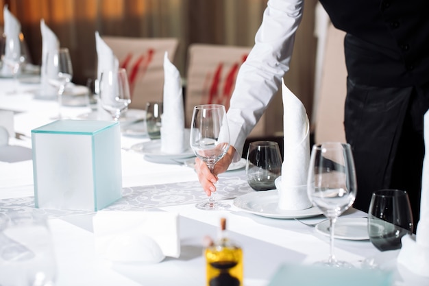Camarero sirviendo mesa en el restaurante preparándose para recibir a los invitados.