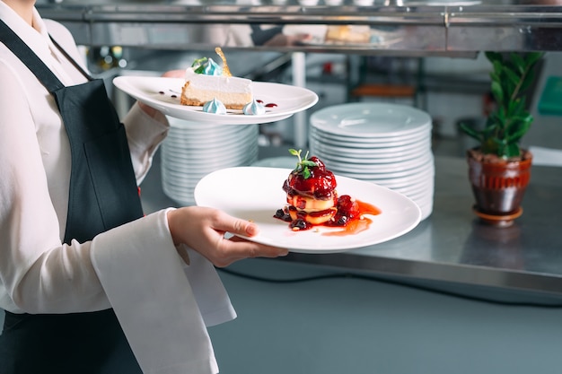 Camarero sirviendo en movimiento de servicio en el restaurante. El mesero lleva platos