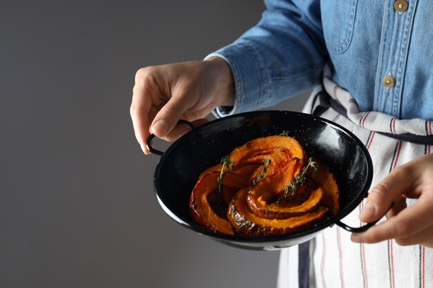 El camarero sostiene el cuenco con calabaza al horno.