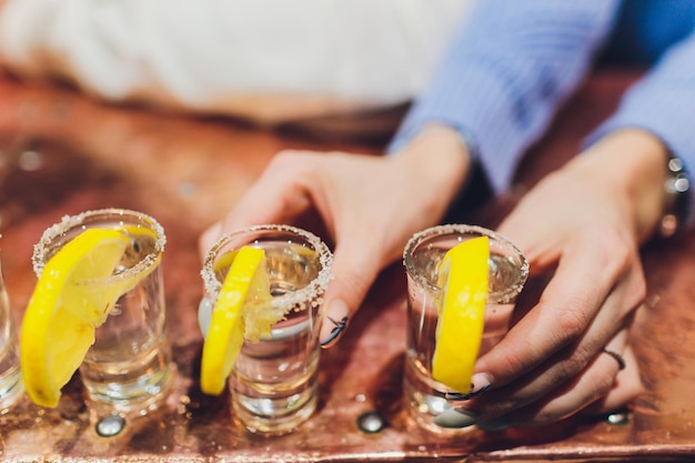 Foto camarero vertiendo bebidas alcohólicas fuertes en vasos pequeños en tragos de bar