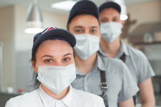 Camareros con máscaras y sombreros médicos.