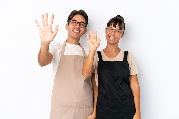 Foto camareros de raza mixta de restaurante aislados en fondo blanco saludando con la mano con expresión feliz