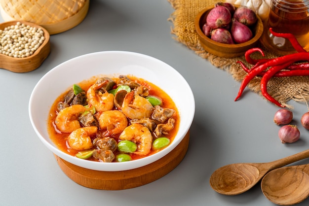 Camarões com pimenta ou Sambal Udang com petai ou pete em prato branco sobre fundo cinza