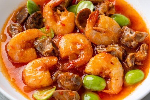 Camarões com pimenta ou Sambal Udang com petai ou pete em prato branco sobre fundo cinza