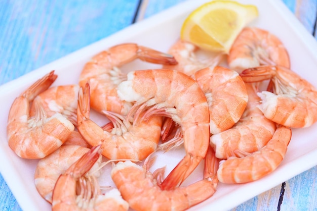 Camarões frescos na bandeja de plástico com camarões de camarão cozidos com limão alimentos cozidos no restaurante de frutos do mar