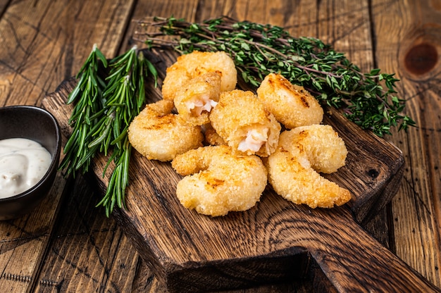 Camarões fritos e crocantes Camarões em uma placa de madeira com molho