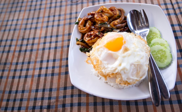 Foto camarões fritos ou camarões com folhas de manjericão, ovo frito com arroz. quente e apimentado