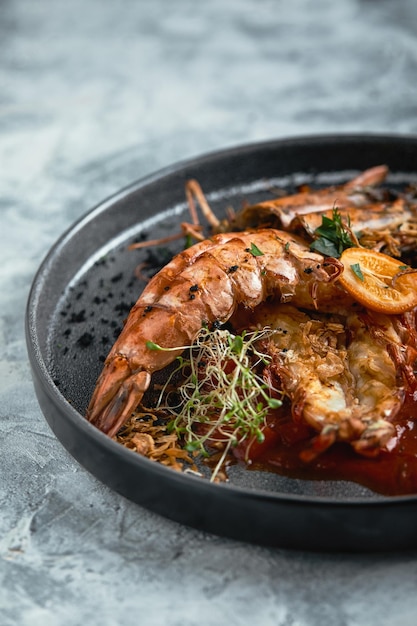 Camarões grelhados com molho de tomate em um fundo cinza chave baixa série de fundo concreto conceito de comida estilo de comida copie a publicidade de comida de espaço para revistas e redes sociais