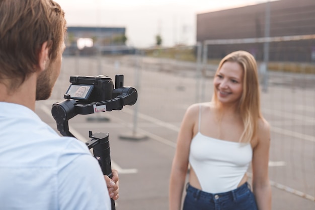 El camarógrafo está filmando a la chica bloguera en la calle