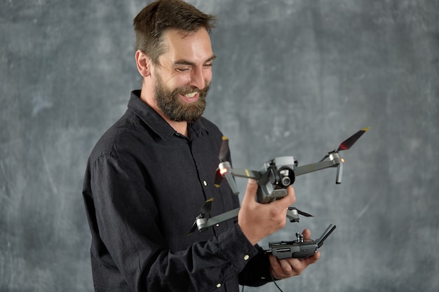 Un camarógrafo feliz sostiene un nuevo quadcopter en su mano