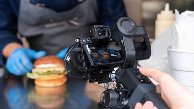 Camarógrafo grabando al cocinero haciendo una hamburguesa, cámara en stadicam. Camión de comida