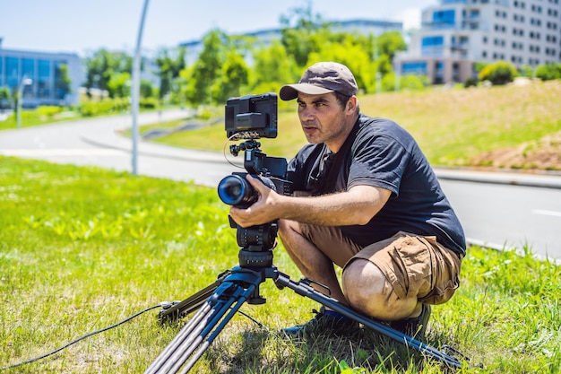 Un camarógrafo profesional prepara una cámara y un trípode antes de disparar.