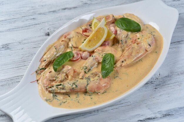 Foto camarones argentinos en salsa de crema sobre una mesa gris, mariscos en salsa, almejas