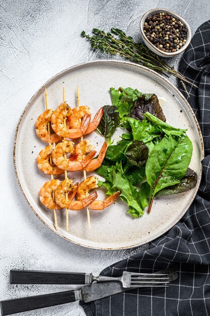 Camarones asados langostinos en brochetas con ensalada de espinacas