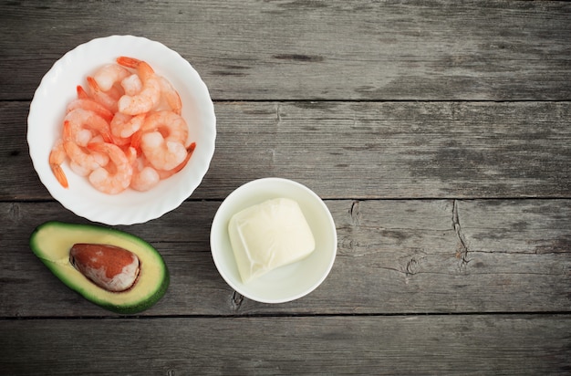 Camarones cocidos con aguacate y mozzarella en la mesa de madera vieja