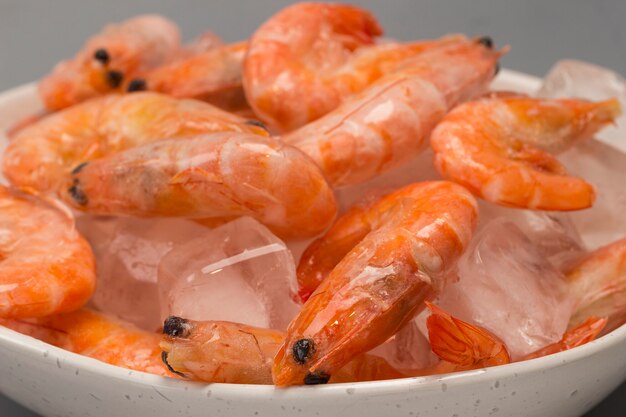 Foto camarones congelados con hielo en un bol.