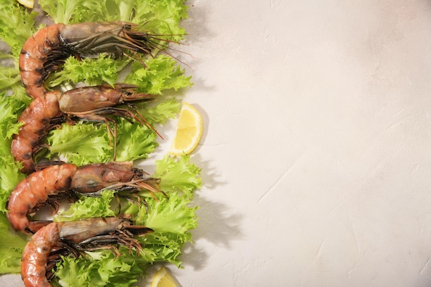 Los camarones crudos se encuentran en las hojas de ensalada verde.