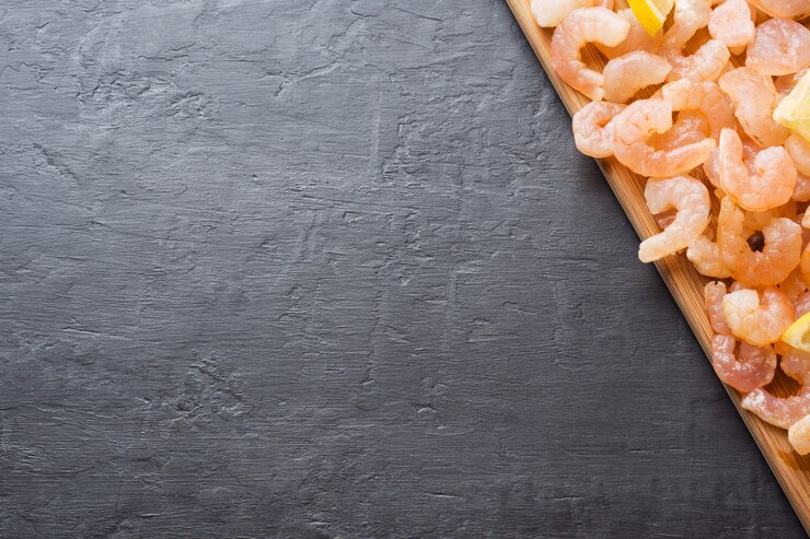 Camarones con especias y limón sobre una plancha de madera