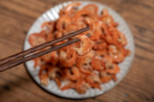 Camarones frescos sin cáscara en un plato o cuenco están sobre una mesa de color madera