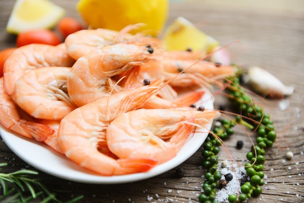 Camarones frescos en un plato blanco y limón