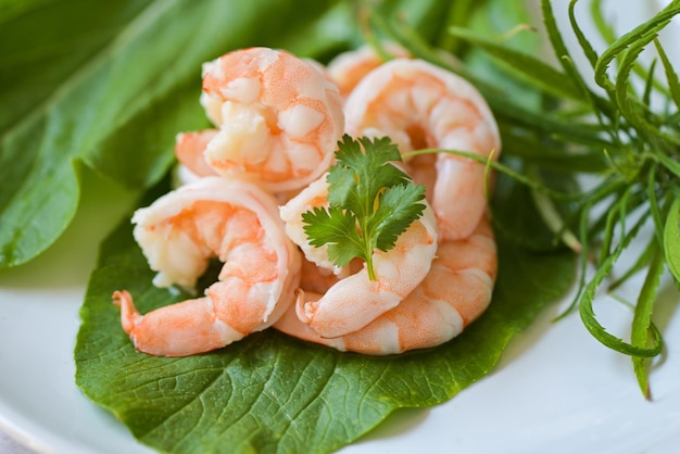 Camarones frescos sobre verduras frescas camarones cocidos langostinos para mariscos con hierba hoja de cannabis y cilantro cocinando camarones hervidos