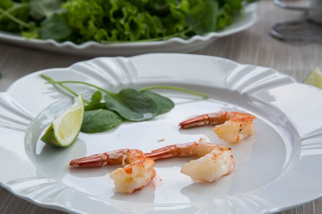 Camarones fritos con limón sobre una placa blanca horno superficie de madera vieja