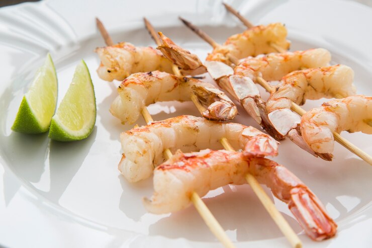 Camarones fritos con limón sobre una placa blanca horno superficie de madera vieja