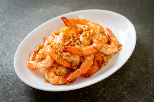 Camarones fritos o gambas al ajillo en un plato blanco - estilo marisco