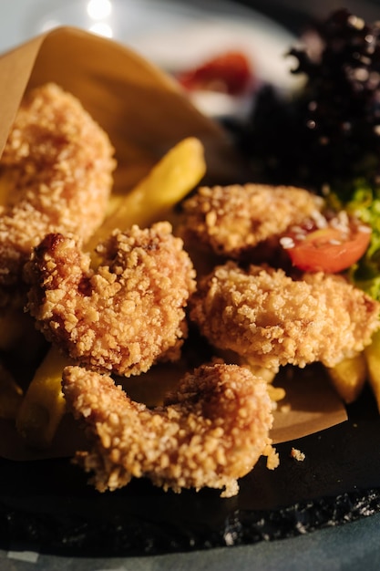 Camarones fritos en pan rallado servidos en papel de comida en un plato