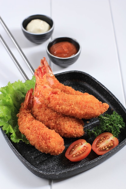 Camarones / gambas en tempura, cocina tradicional japonesa hecha de camarones fritos cubiertos con pan rallado o panko, generalmente se encuentra como menú de almuerzo Bento. Sobre fondo blanco de madera