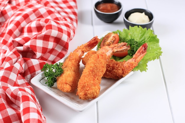 Camarones / gambas en tempura, cocina tradicional japonesa hecha de camarones fritos cubiertos con pan rallado o panko, generalmente se encuentra como menú de almuerzo Bento. Sobre fondo blanco de madera