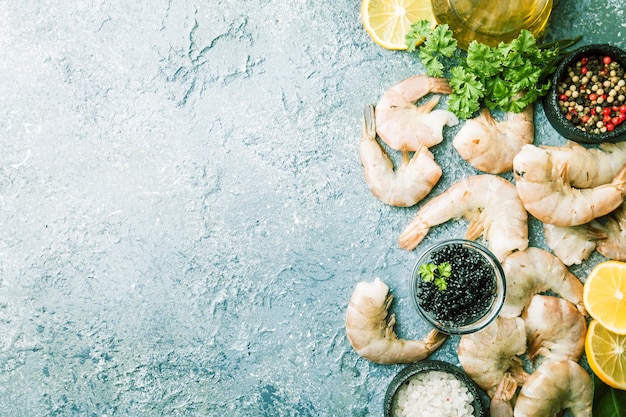 Camarones gigantes crudos con limón y especias sobre gris