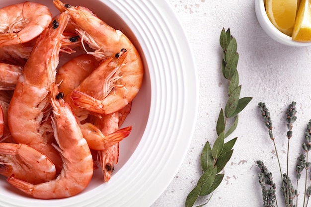 Camarones hervidos en un plato blanco con limón.