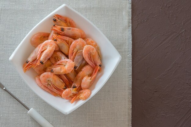 Camarones hervidos en un plato blanco sobre una servilleta de tela