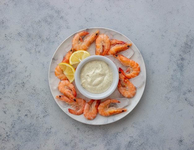 Camarones en hielo con salsa blanca.