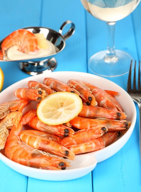 Foto camarones con limón en plato sobre mesa de madera closeup