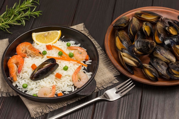 Foto camarones y mejillones con arroz en sartén mejillones en plato