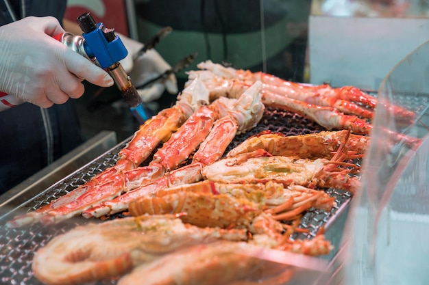 Los camarones a la parrilla y el cangrejo a la parrilla son fuego y se cocinan en el mercado de pescado de Japón