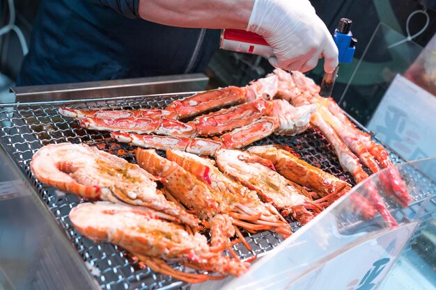 Los camarones a la parrilla y el cangrejo a la parrilla son fuego y se cocinan en el mercado de pescado de Japón