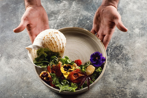 Foto camarones a la plancha y ensalada de verduras en la placa blanca.